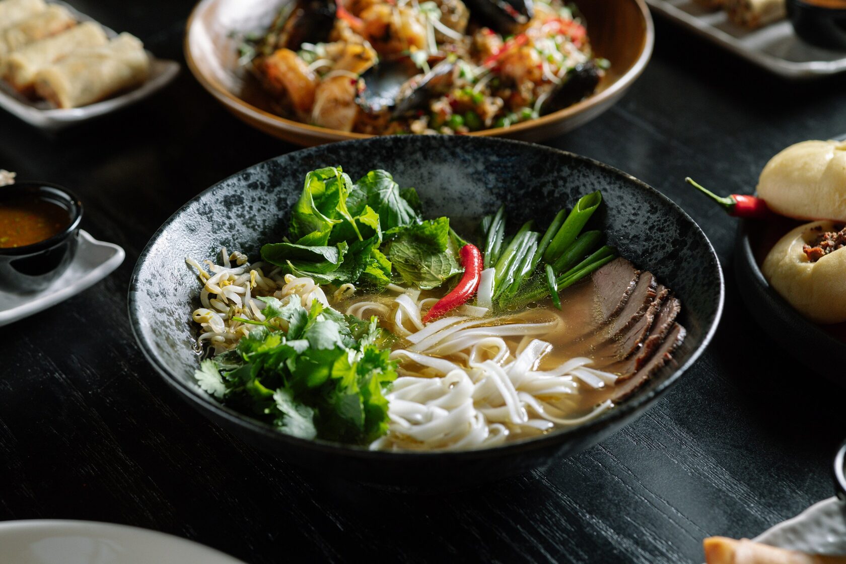 Фо бо с говядиной, рисовой лапшой, зеленью и ростками в ресторане Black Thai.