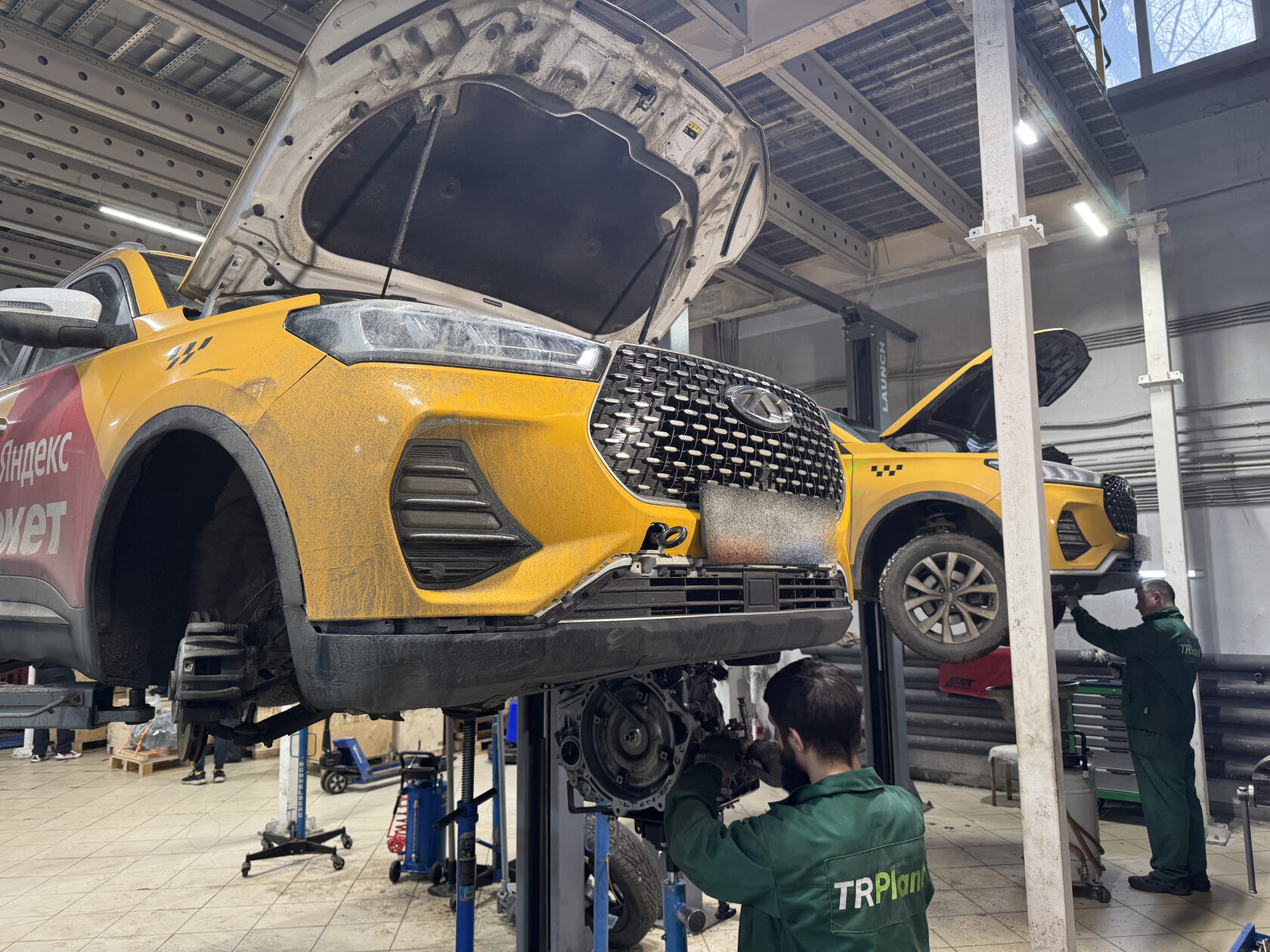 Мастера ТРПЛАНТ снимают вариатор с Chery на подъёмнике в цеху