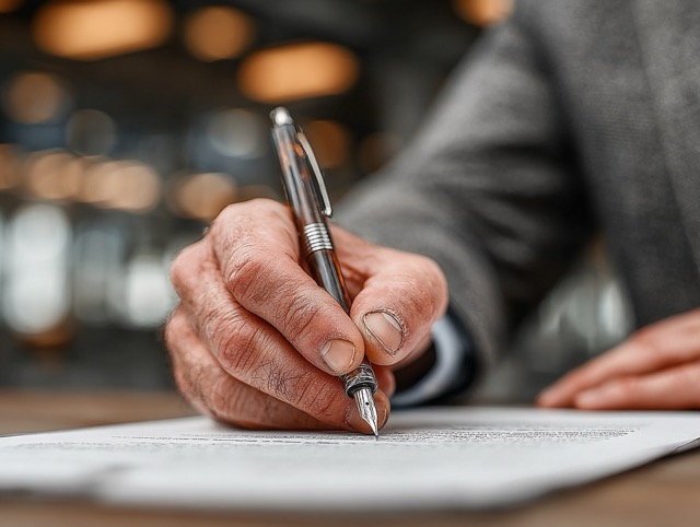 Бизнесмен подписывает документы о ликвидации компании, офисный стол, юридические бумаги