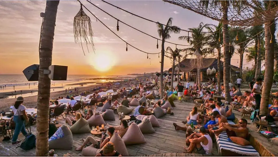 Crowded beach club in Canggu overlooking the beach during sunset