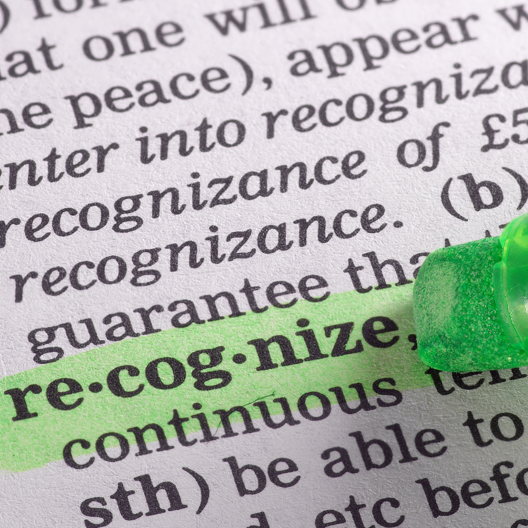 a page from the dictionary with a green highlighter over the word recognize