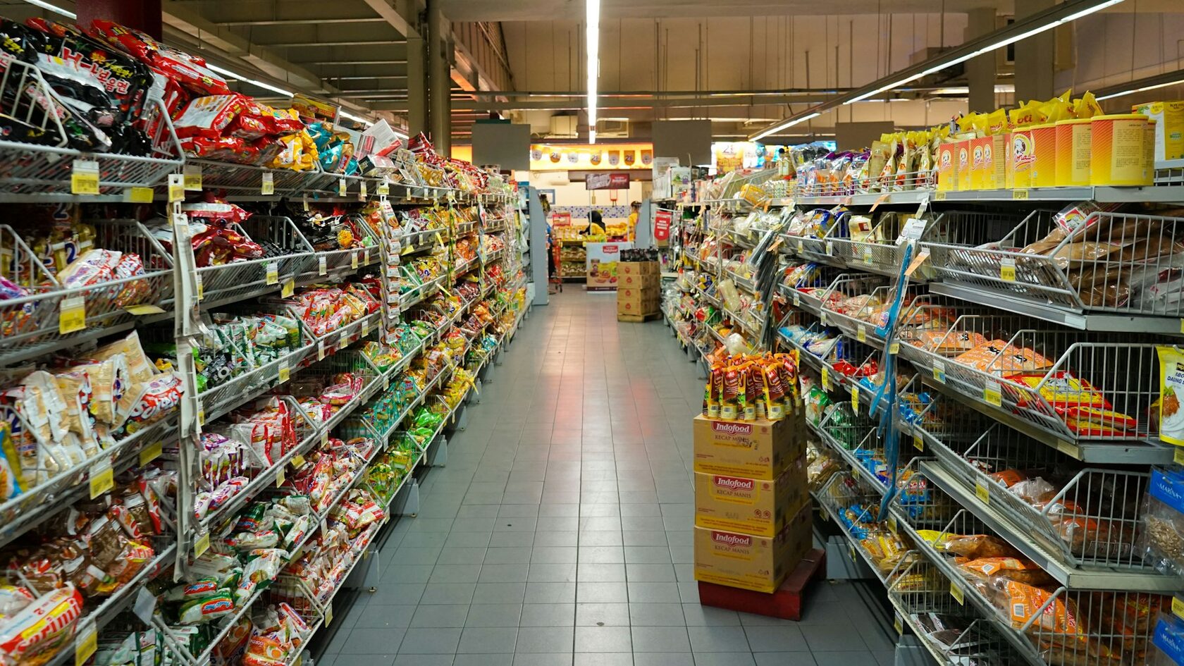 A supermarket aisle with metal shelves of packaged food