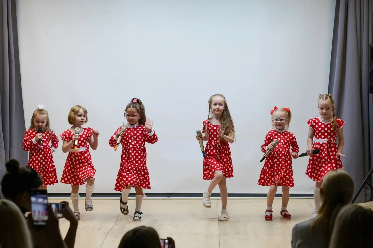 Маленькие девочки выступают на концерте и поют