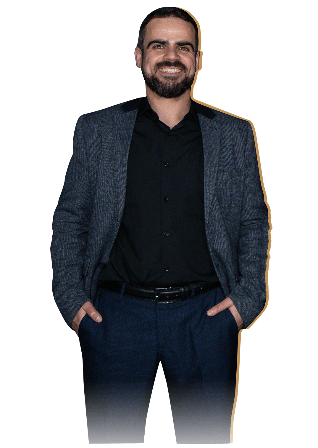 Артём Коплевенко стоит и улыбается, держит руки в карманах, в пиджаке и брюках, смотрит прямо