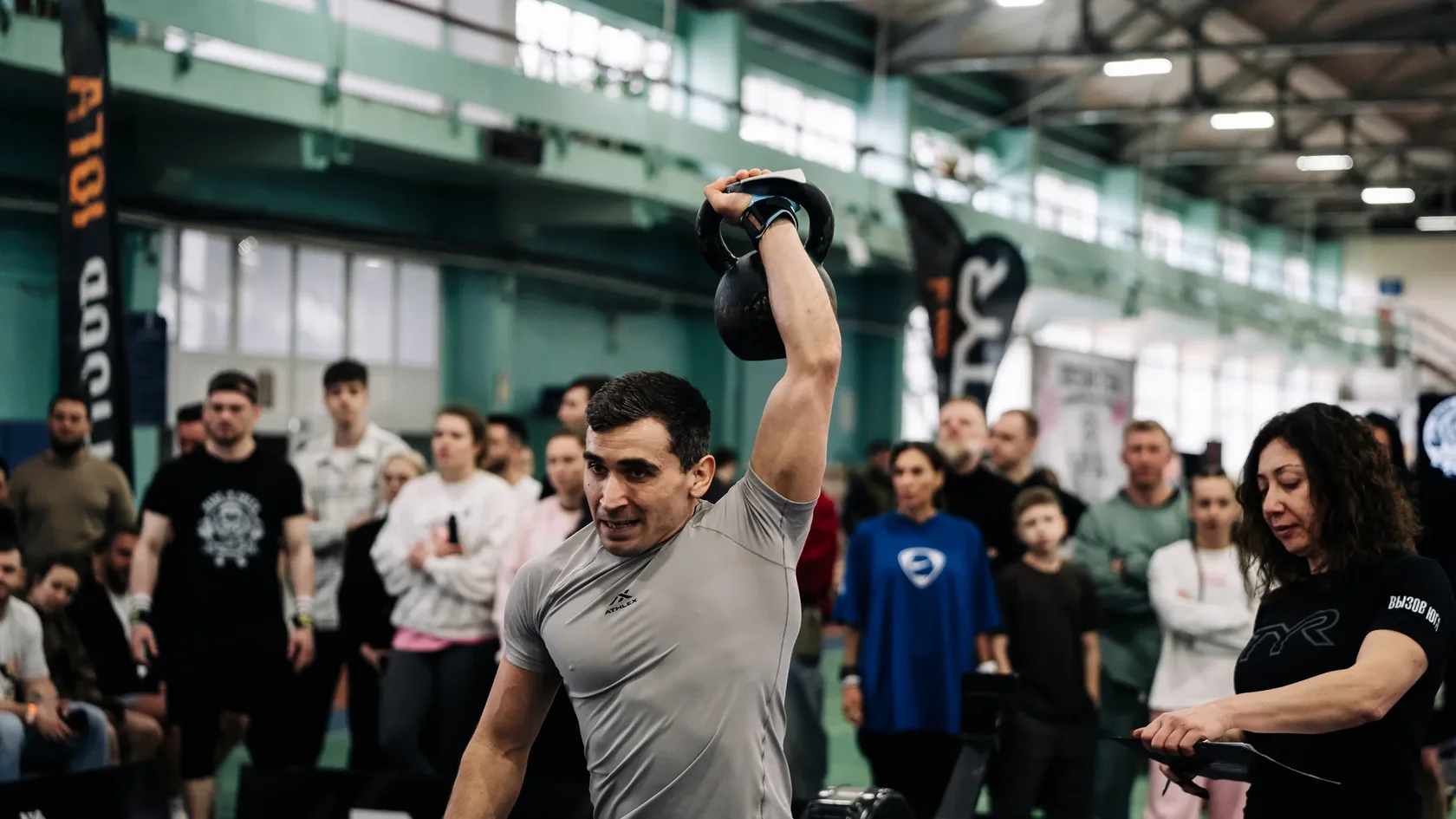 Атлет, судья и зрители на соревновательной площадке
