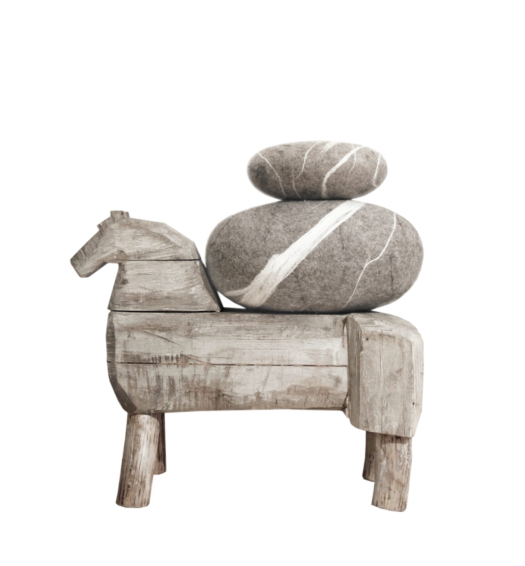 Два войлочных пуфа-камня КАТСУ разных размеров и моделей лежат на винтажной скамейке в форме лошади