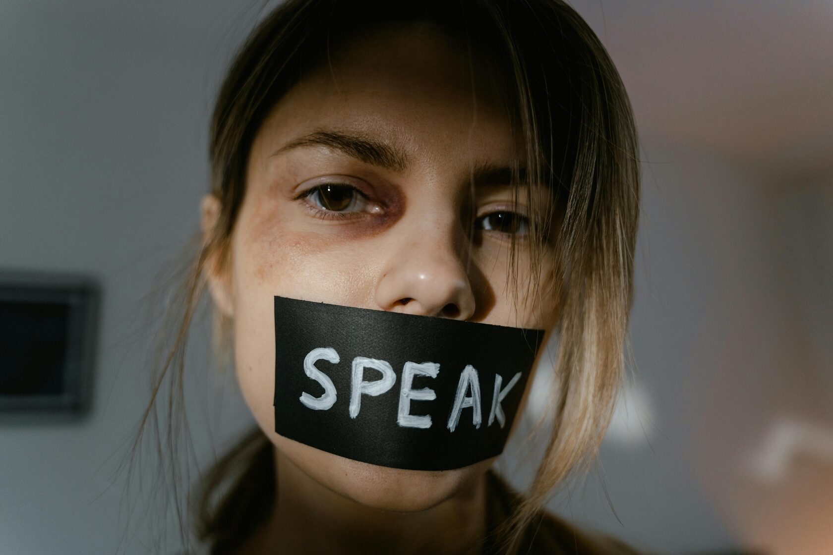 A woman suffering from domestic violence, unable to speak up about her injuries and seeking help in silence.
