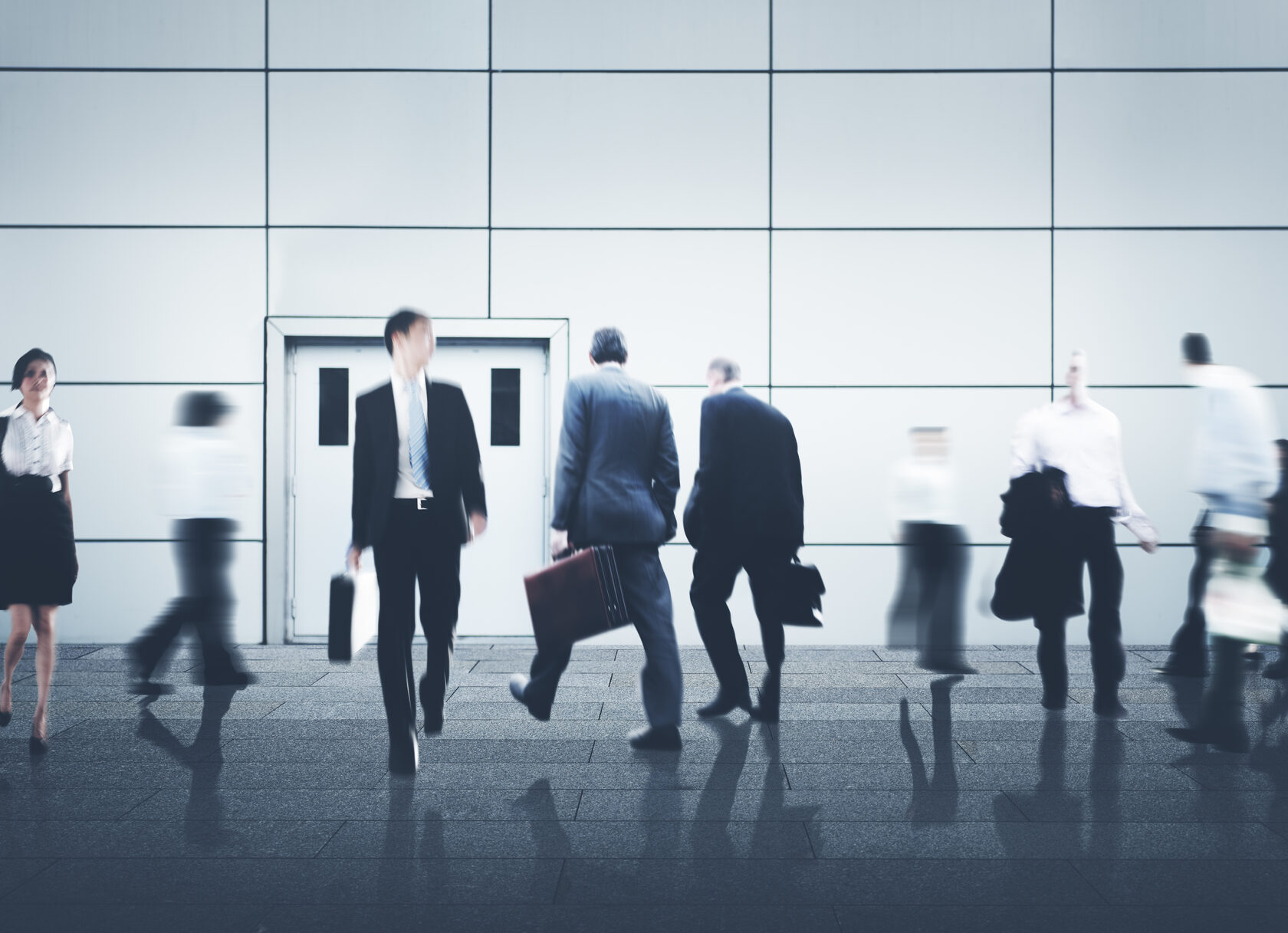 Business people walking in modern office building with motion blur