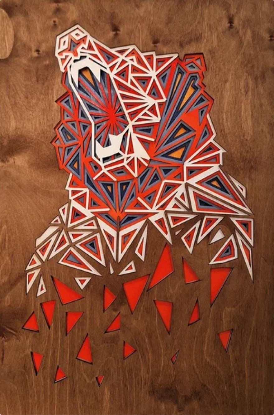 Панно из дерева, изображающее голову ревущего медведя, созданное из красных, белых и синих цветов. Открытая пасть медведя придают ему динамичный вид