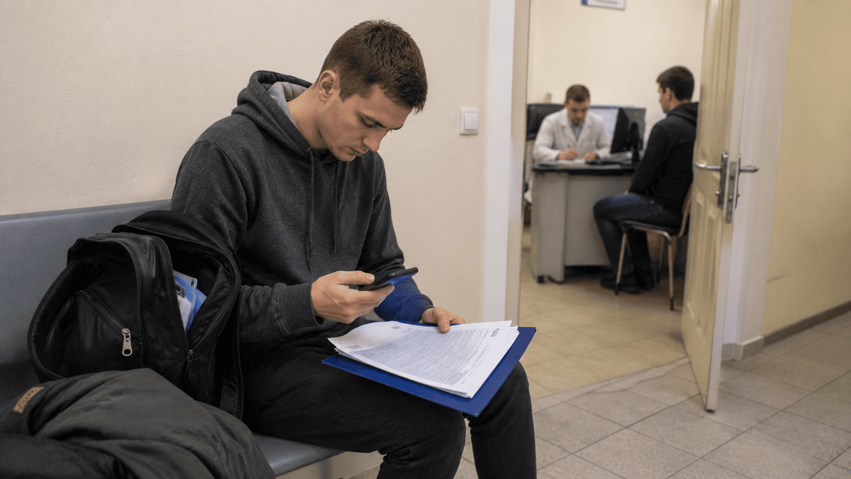 Врач на медкомиссии изучает документы призывника