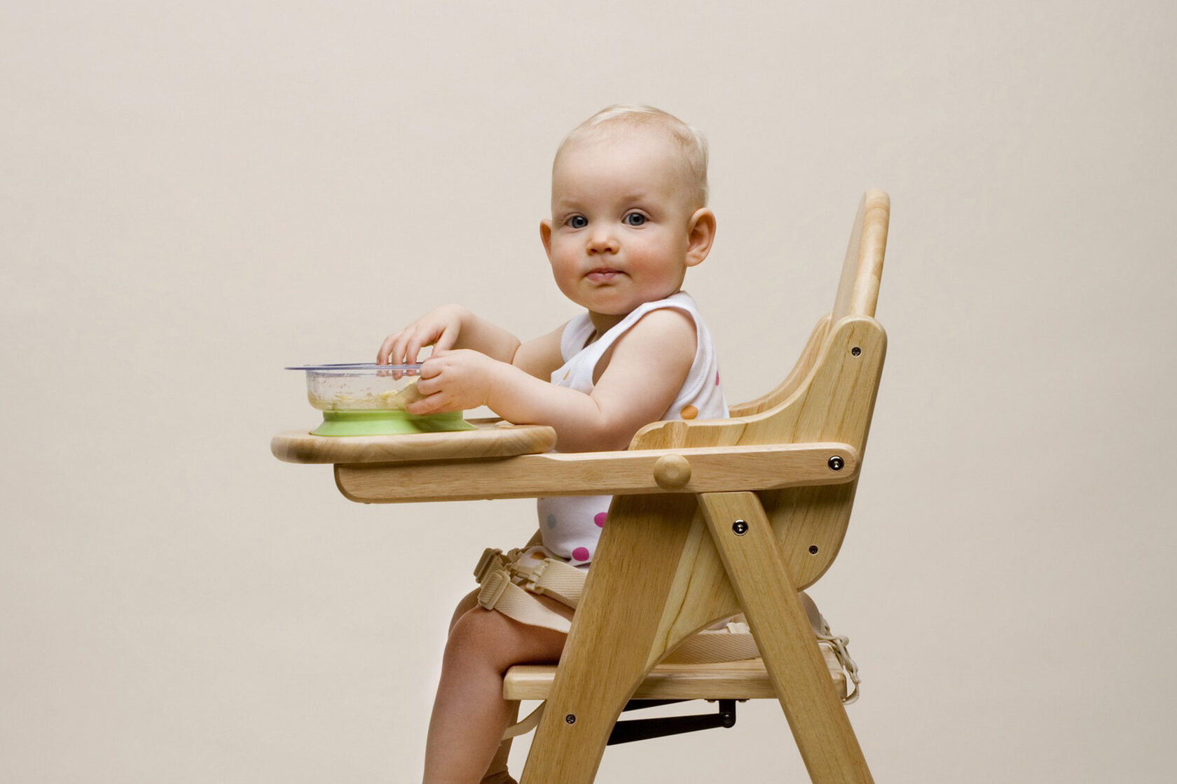 Малыш сидит на стульчике для кормления
