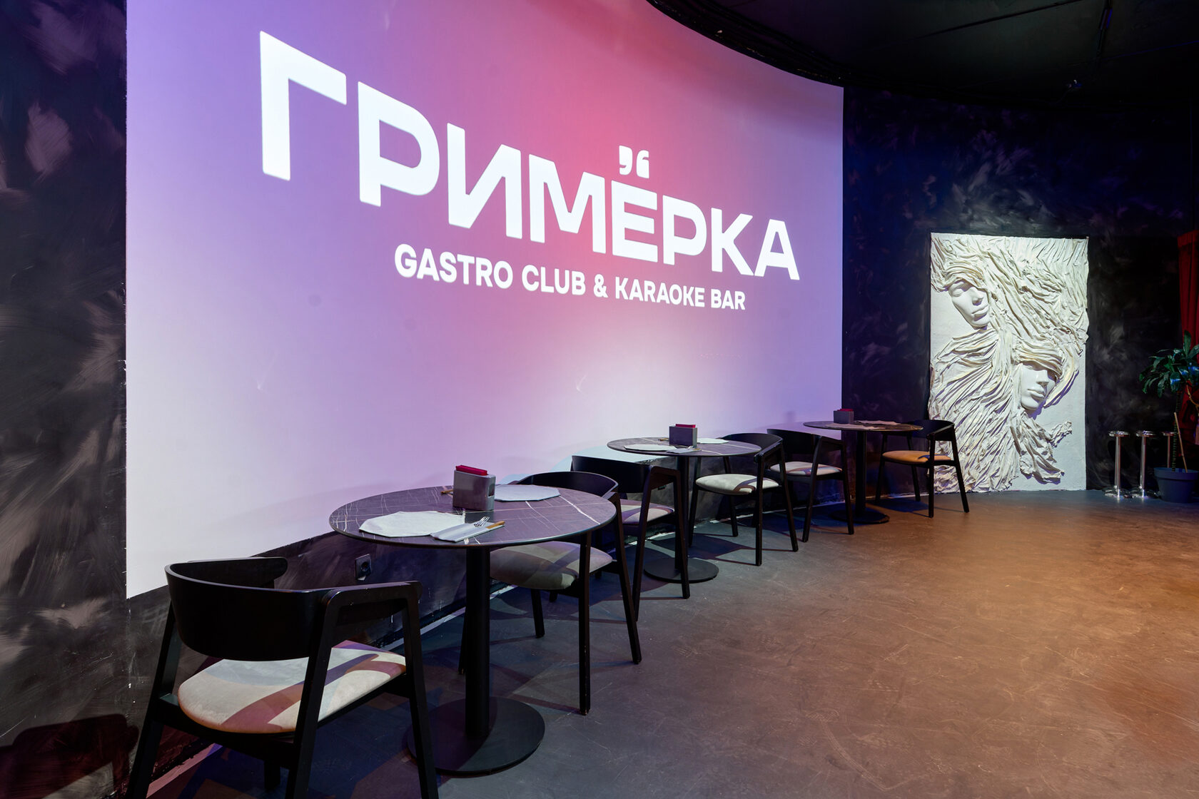 Столы у большого экрана с логотипом «Гримёрка»