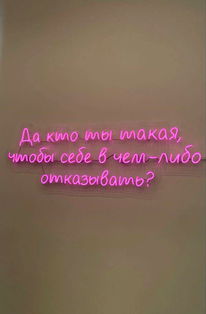 Розовая неоновая надпись на стене с цитатой «Да кто ты такая, чтобы себе в чем-либо отказывать?»