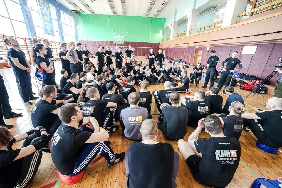 Участники слушают инструктора во время группового тренинга KMG