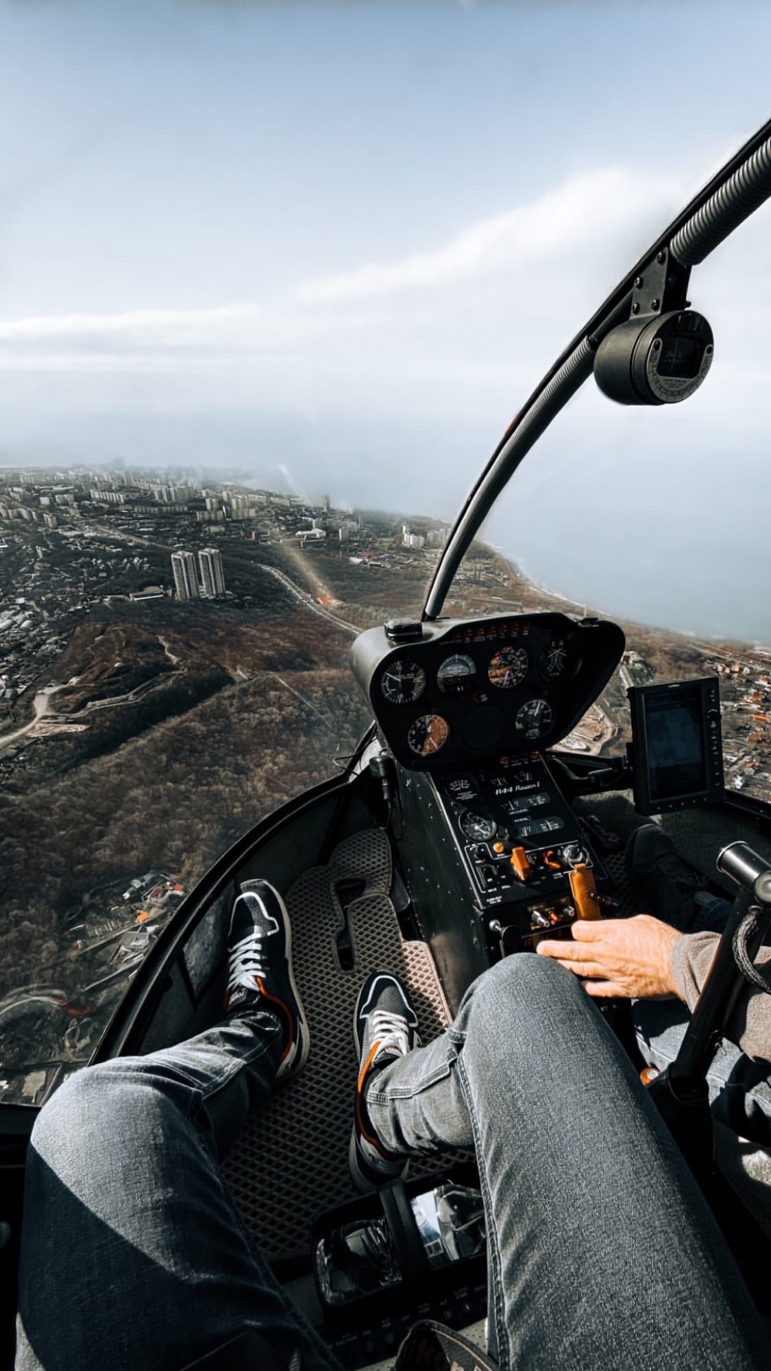 Пассажиры фотографируются на борту во время экскурсии на вертолете над мостами Владивостока