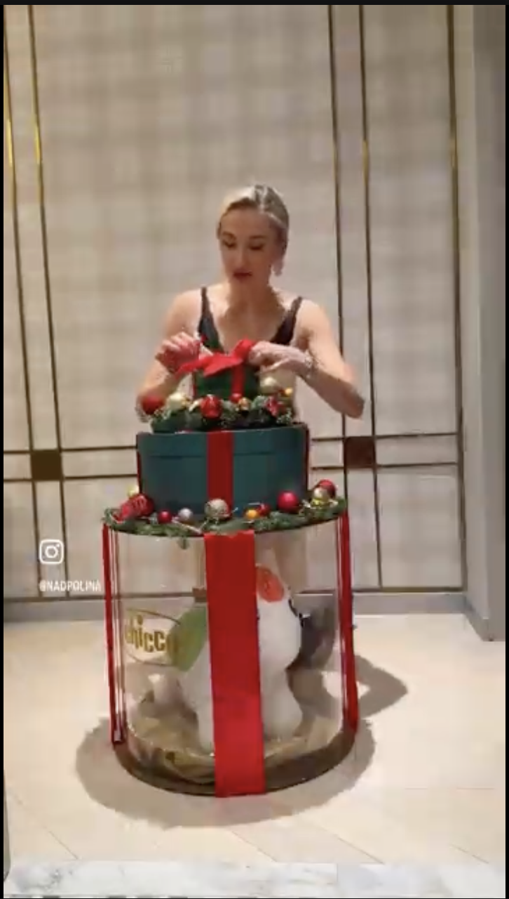 Девушка показывает подарок Chicco