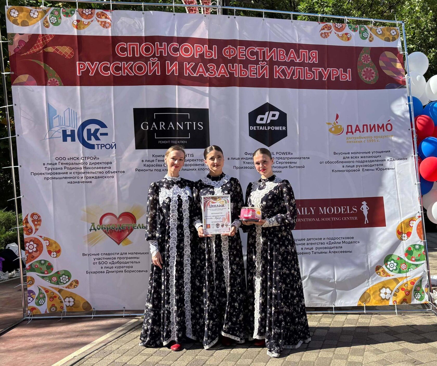 Ансамбль «Душа» от ЦКР «Арт-пространство» на фоне баннера спонсоров Фестиваля русской и казачьей культуры в Краснодаре, октябрь 2025 года. Участницы держат диплом и сладкие подарки, вручённые за участие в праздничной программе.
