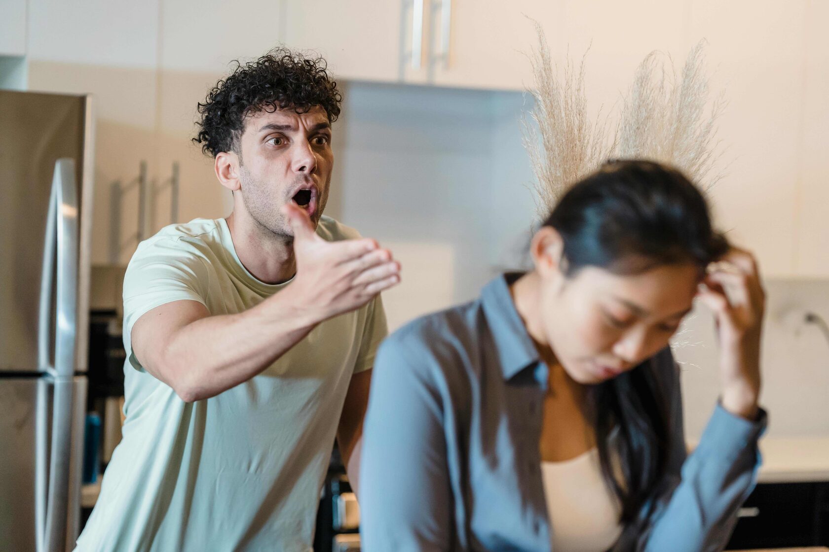 A couple arguing intensely in a domestic setting, illustrating signs of domestic violence and relationship conflict.