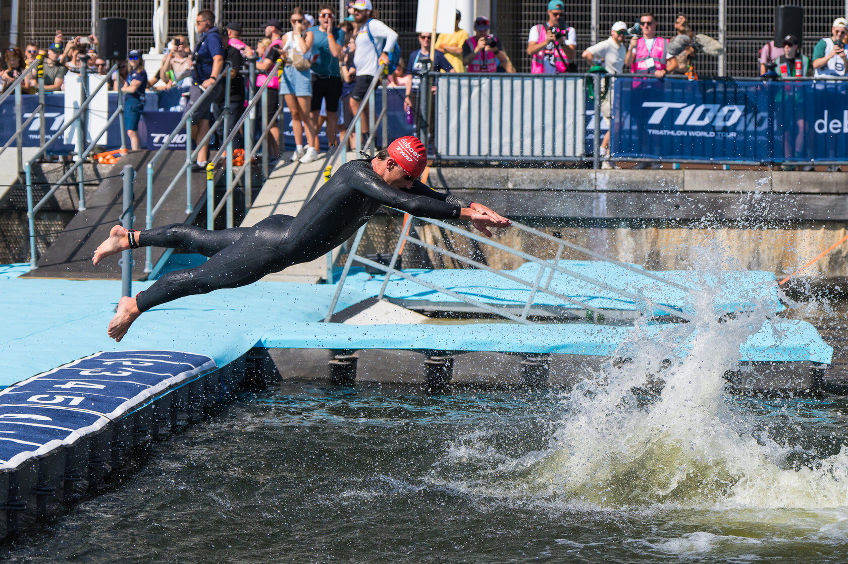Прыжок спортсменов в воду на старте триатлона