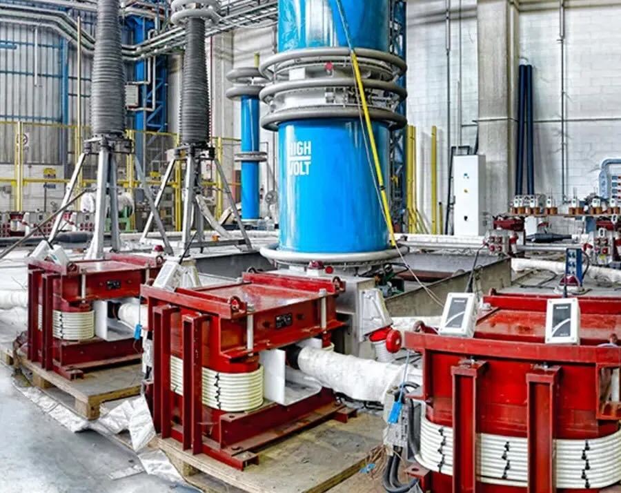 a factory with a bunch of red machines and a large blue cone