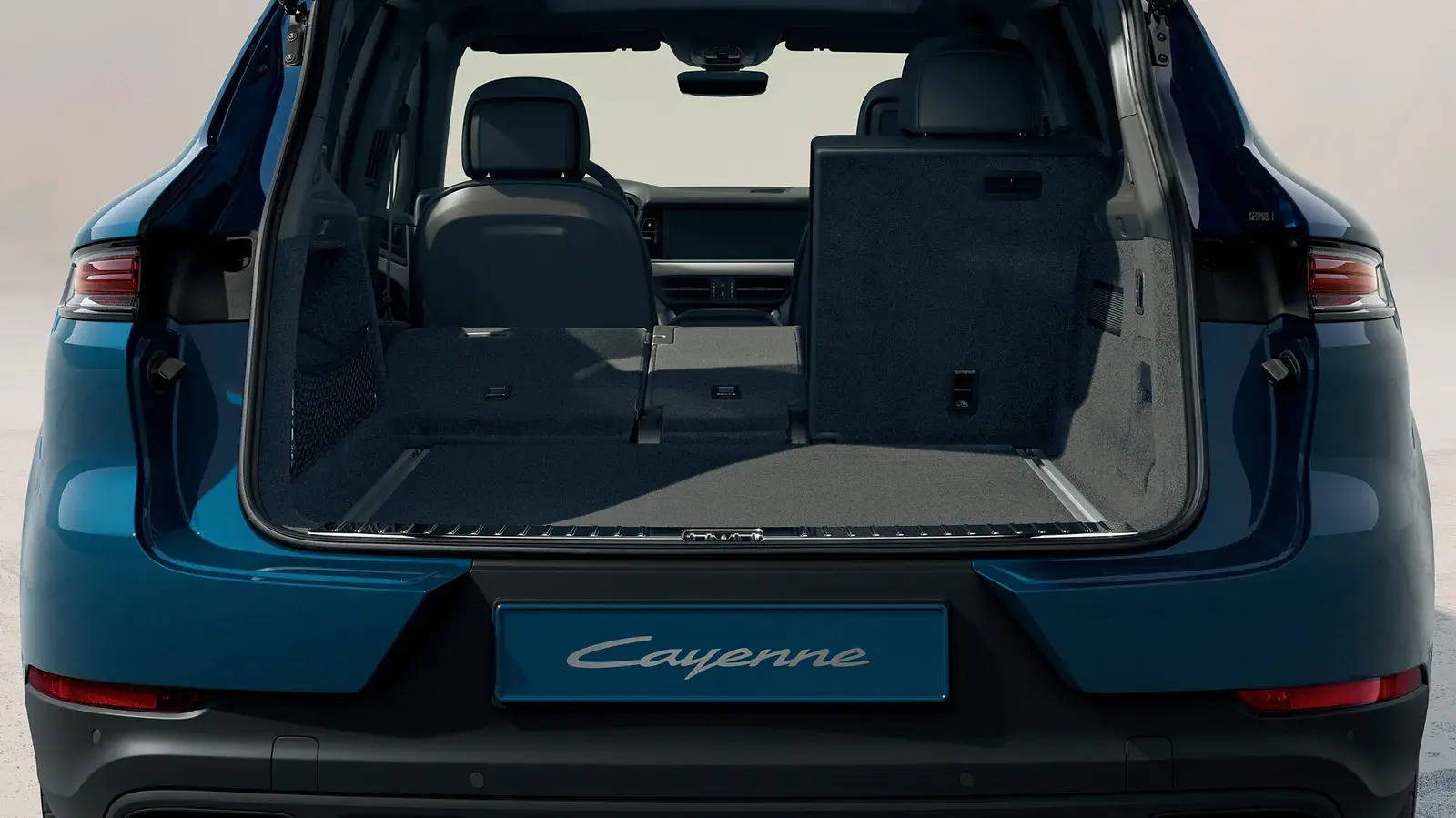 Porsche Cayenne в цвете Montegoblau Metallic. Вид сзади с открытым багажником.