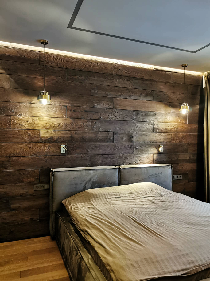 деревянная стена за серой кроватью, подвесные светильники