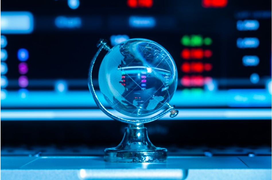 Why is trading important: A transparent glass globe sits on a reflective surface, illuminated by blue light, with a blurred background of crypto trading data screens showing red and green numbers