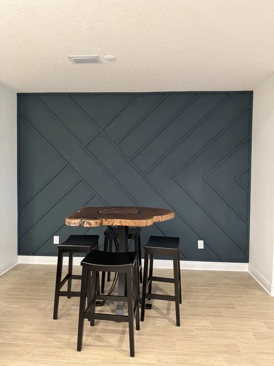 Finished geometric board and batten accent wall behind a dining table in Bradenton, Florida