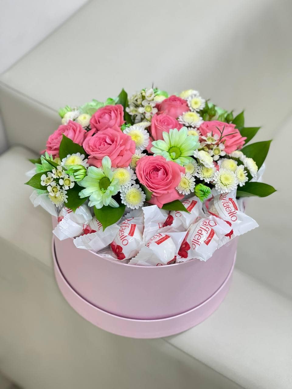 Букет цветов в коробке с конфетами. Нежные цветы и изысканные конфеты Рафаэлло складываются в уникальное сочетание. Доставка 