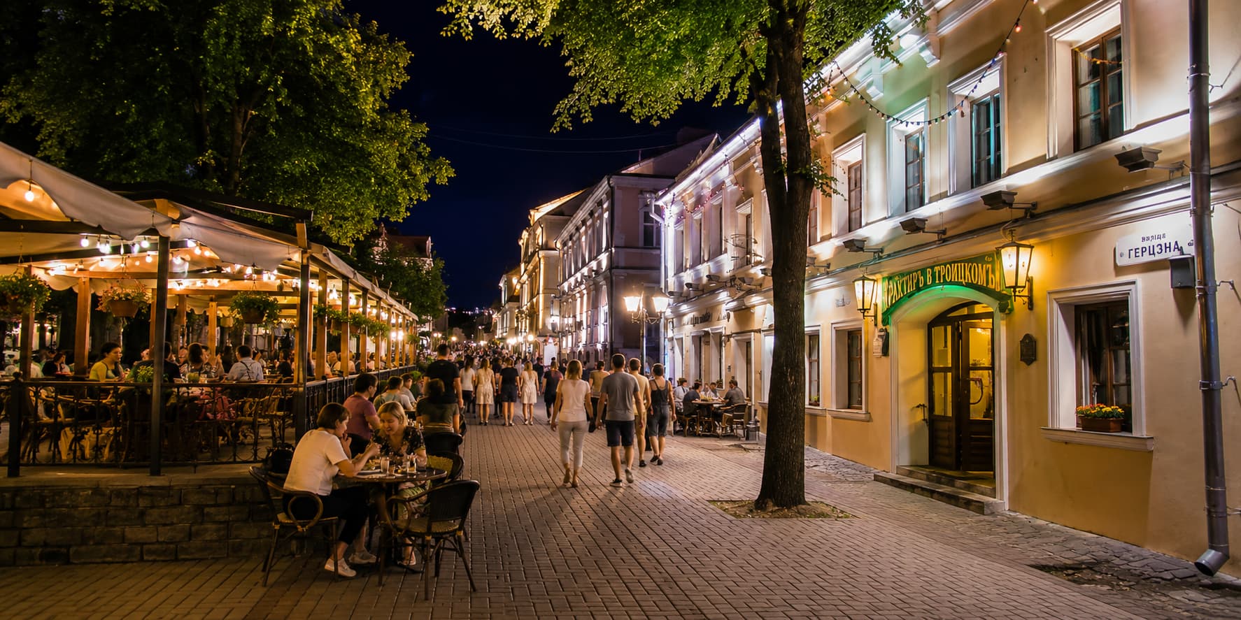 Evening atmosphere of Trinity Suburb in Minsk with cozy cafés, outdoor terraces, historic streets, and cultural events in the city center near Center Rooms Hostel.