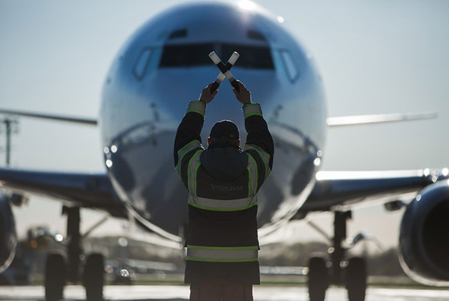 співробітник подає сигнали літаку