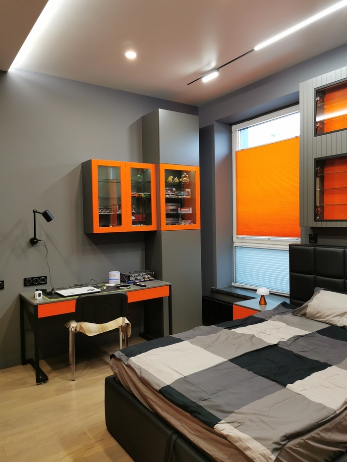 серая комната в стиле хай-тек с оранжевым плиссе, оранжевыми полками, трековым светом