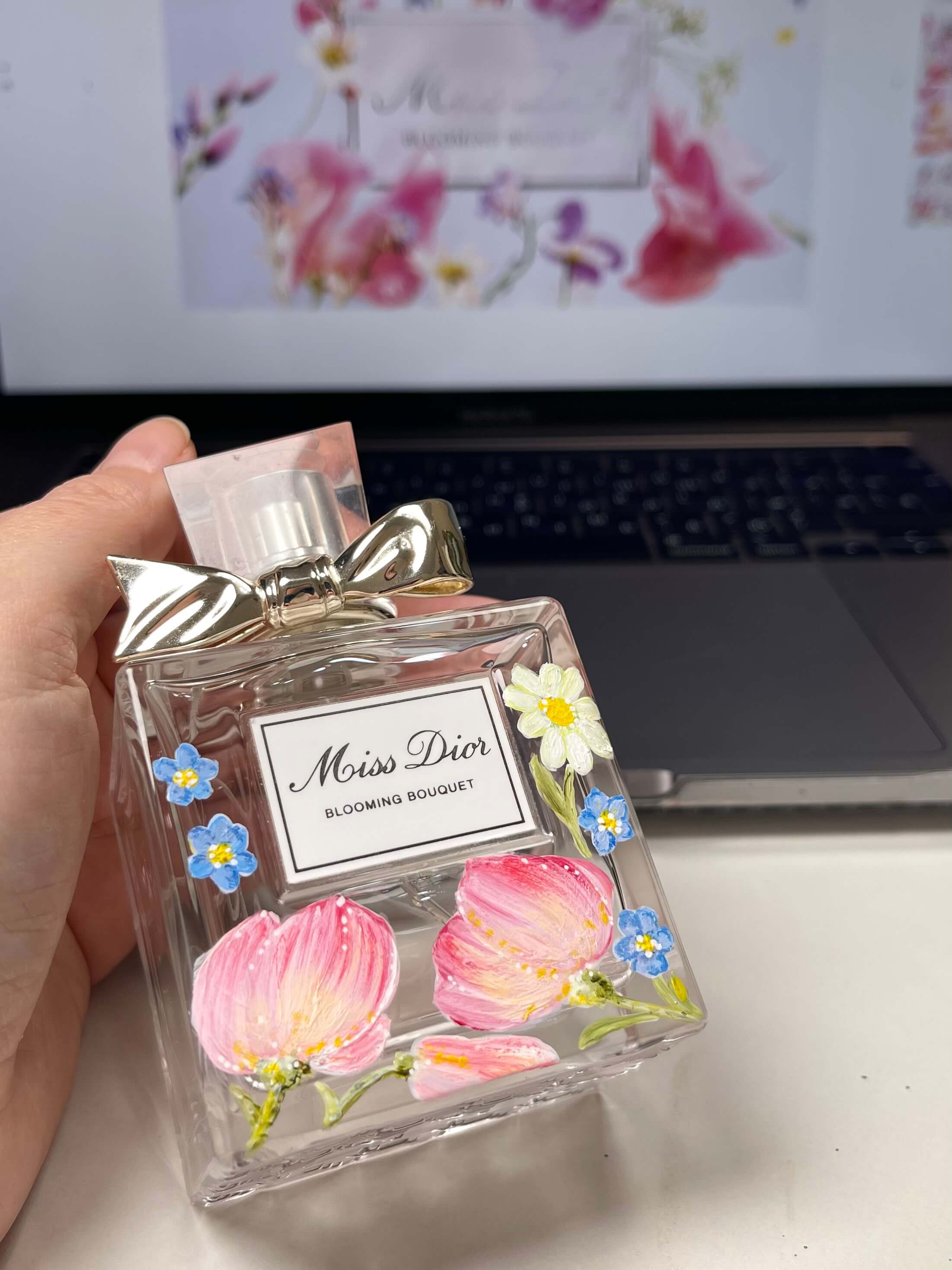 Custom hand-painted Miss Dior Blooming Bouquet perfume bottle with delicate pink and blue floral artwork by Julia Razz.