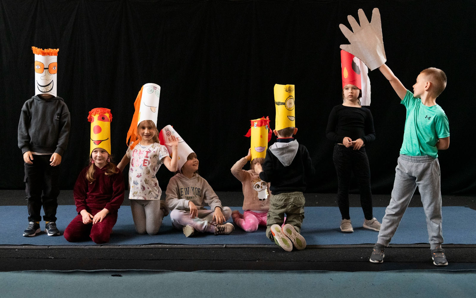 Children with paper masks on stage