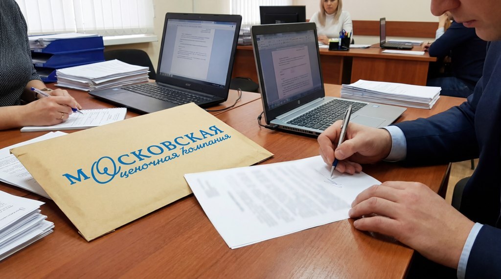 Человек подписывает документы в офисе.