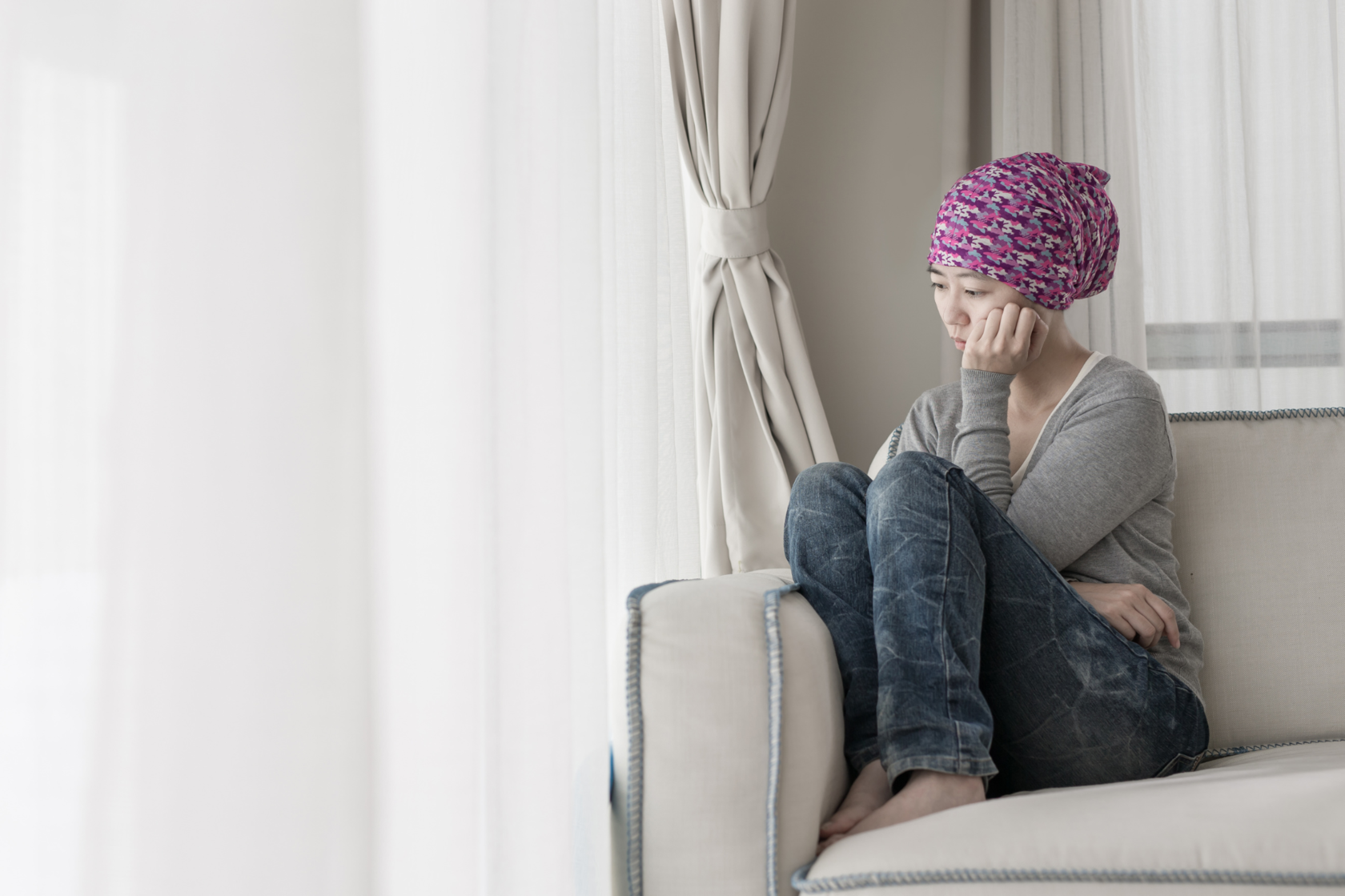 Depressive Frau schaut aus dem Fenster