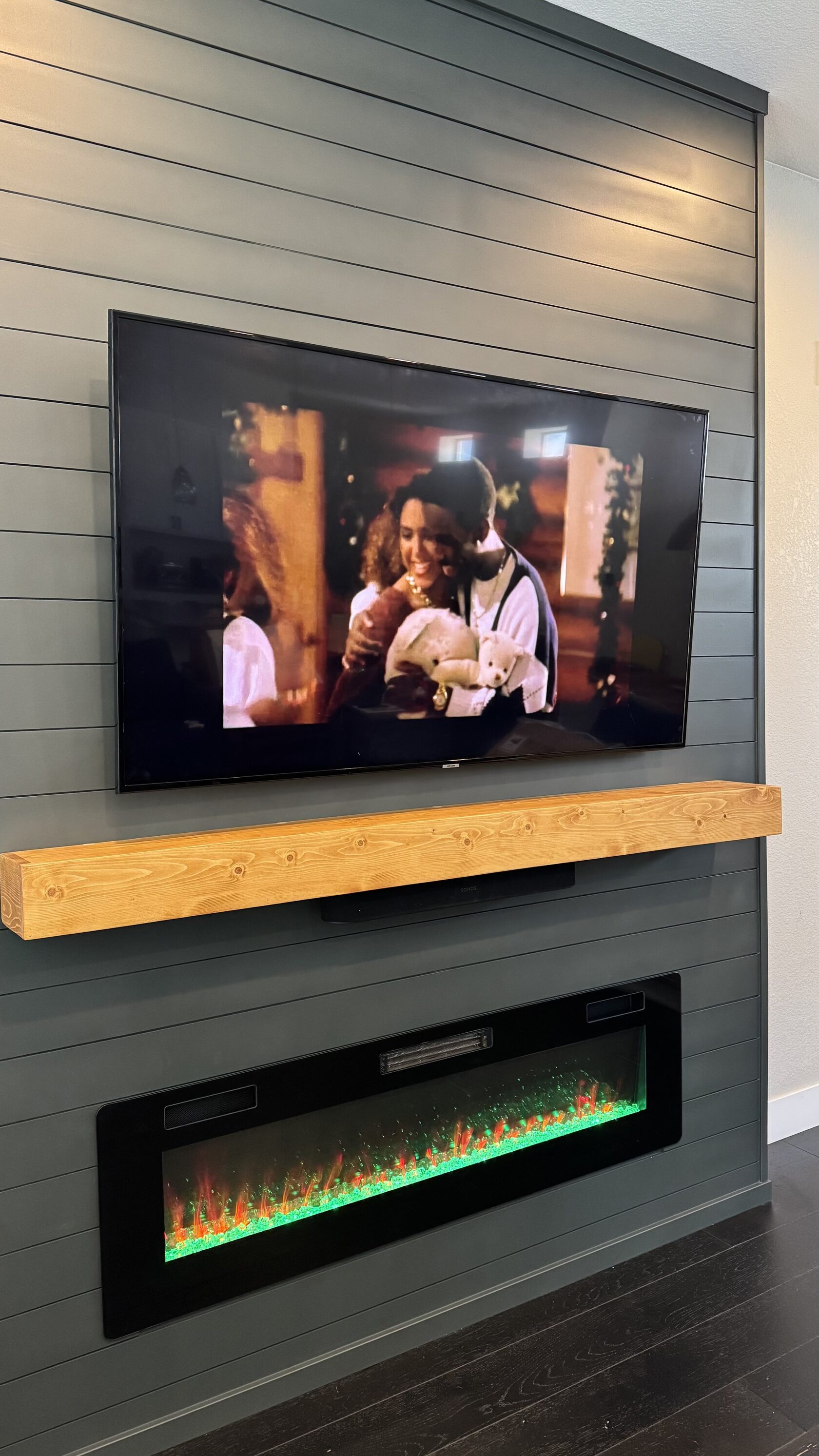 Dark horizontal shiplap TV wall with a wood mantel and fireplace in Napa, California.