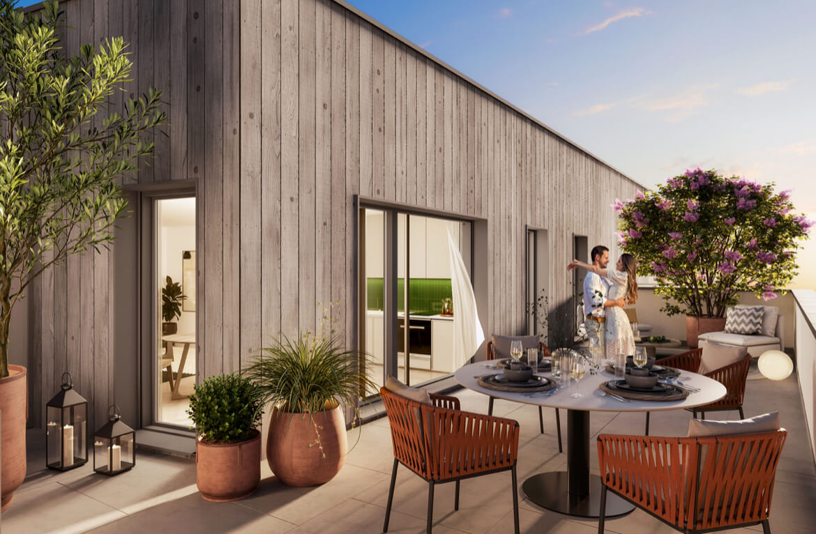 A cozy terrace of a modern house with wooden paneling, decorated with green plants, candles, and stylish furniture. A round table is set in the center, and a lounge area is located in the background. A romantic atmosphere is created by a couple enjoying t