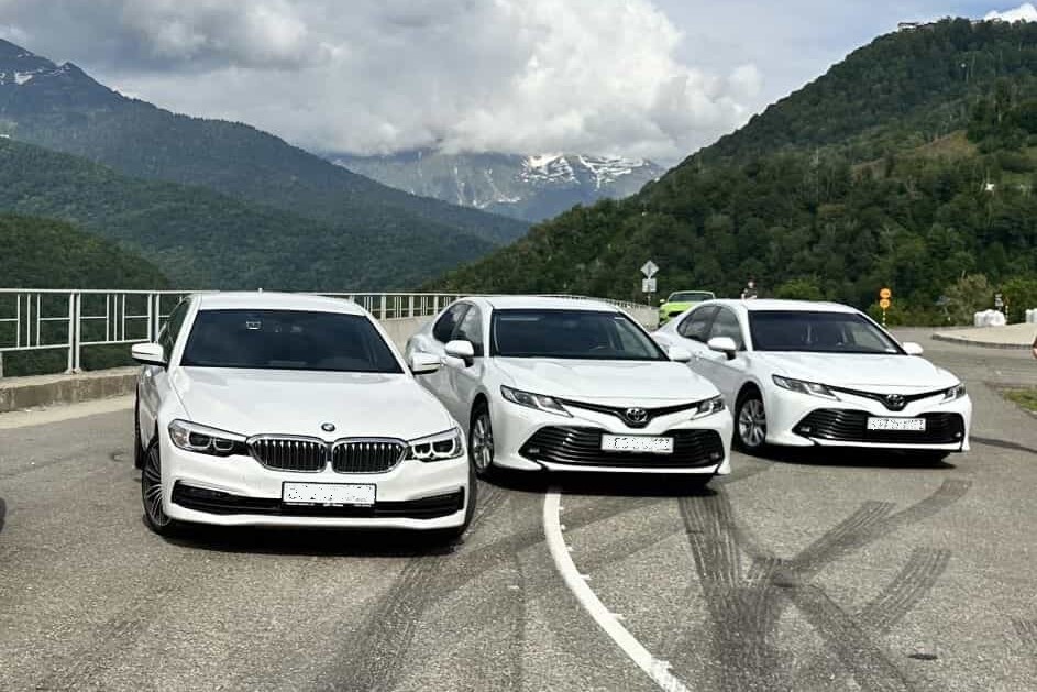 Автомобили такси класса комфорт плюс на фоне гор Красной поляны 