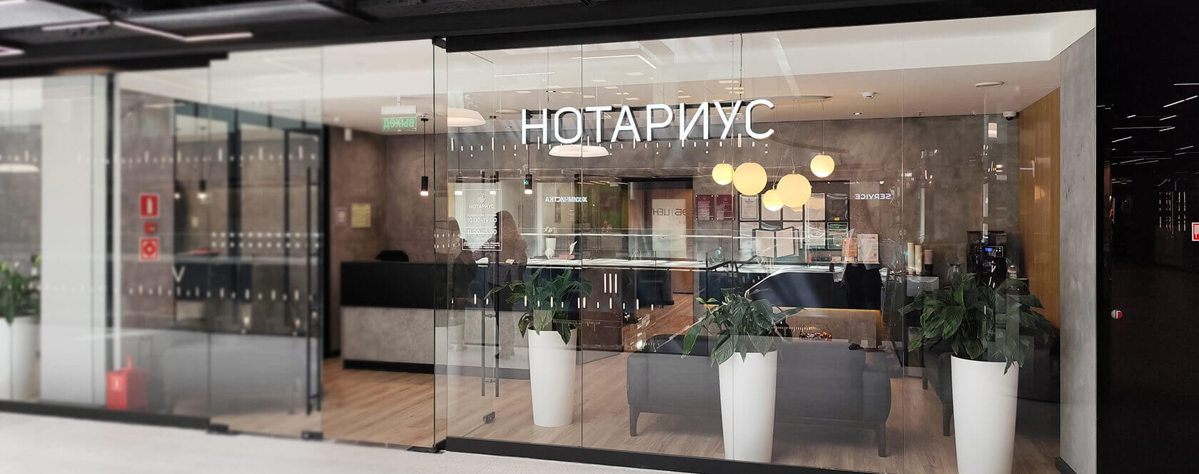 Комфортный зал нотариальной конторы с уютными диванами и живыми растениями в горшках