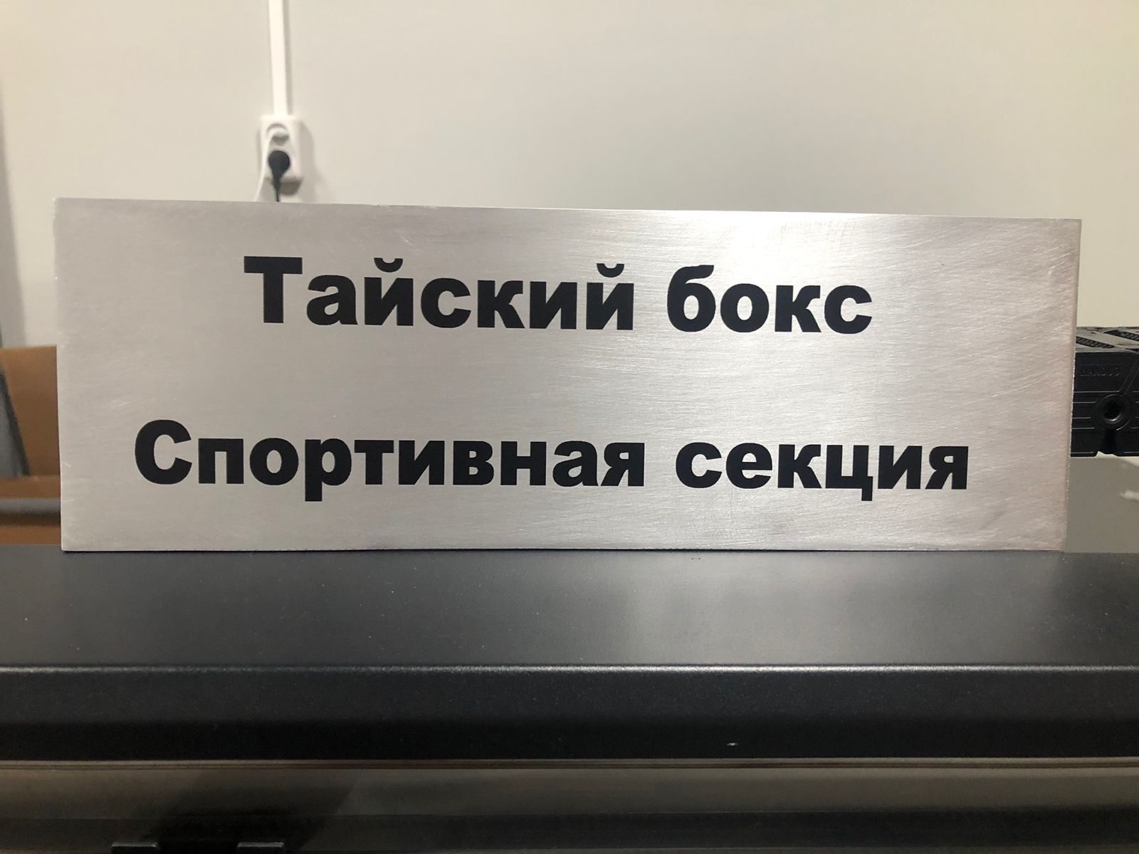 На изображении табличка из металла с надписью «Тайский бокс". Надпись напечатана на УФ принтере.