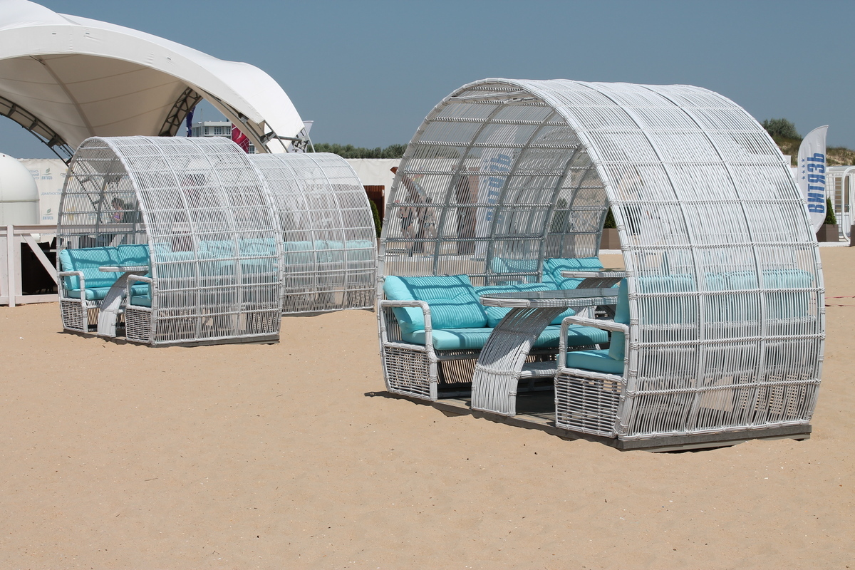 Стильная мебель из искусственного ротанга у бассейна, устойчивая к солнечным лучам и влажности.