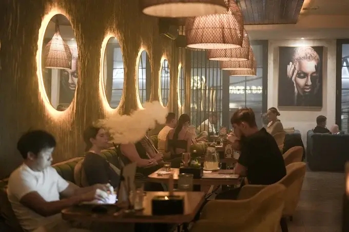 Digital nomads and remote workers staying productive and unwinding in the warm, atmospheric lounge of the Eden Uluwatu venue, the best coworking space in Bali.