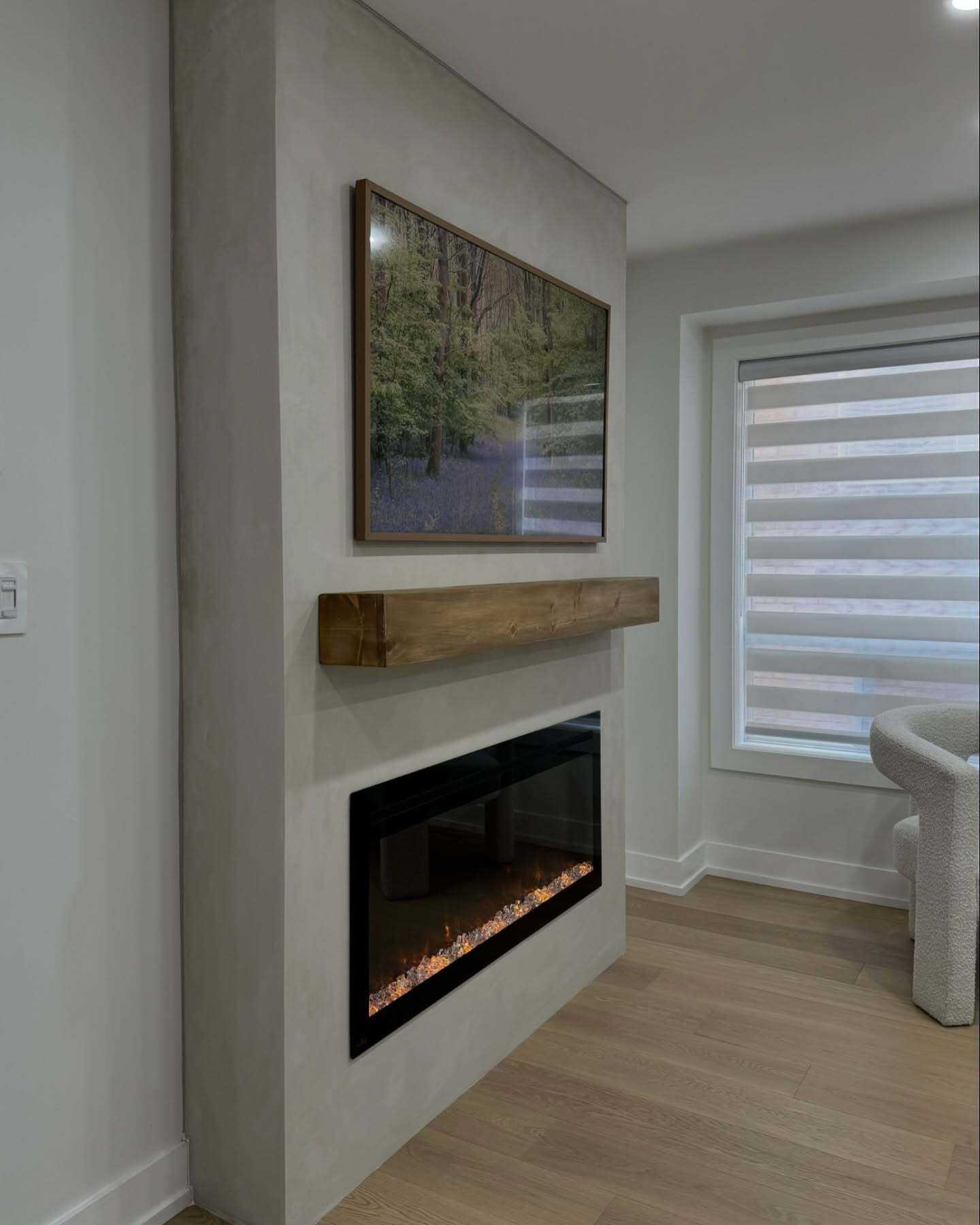 Side view showing the depth of the custom fireplace build-out beside a living room window.