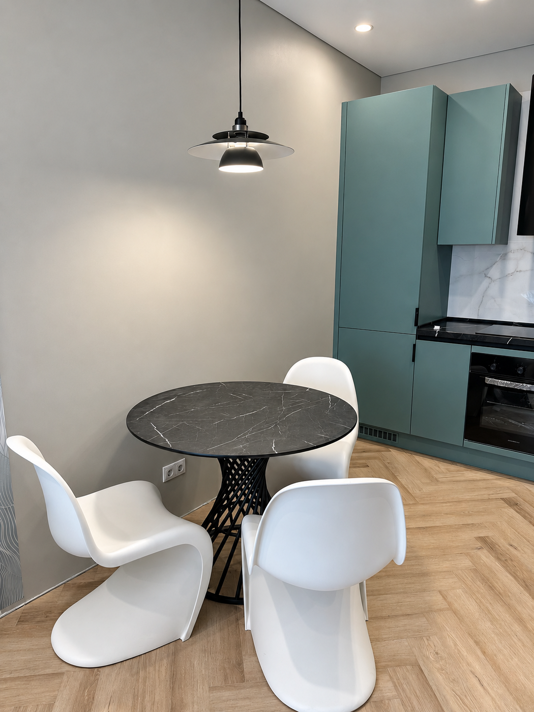 Круглый стол LoFTable с тёмной столешницей под камень и ажурным чёрным подстольем на кухне заказчика