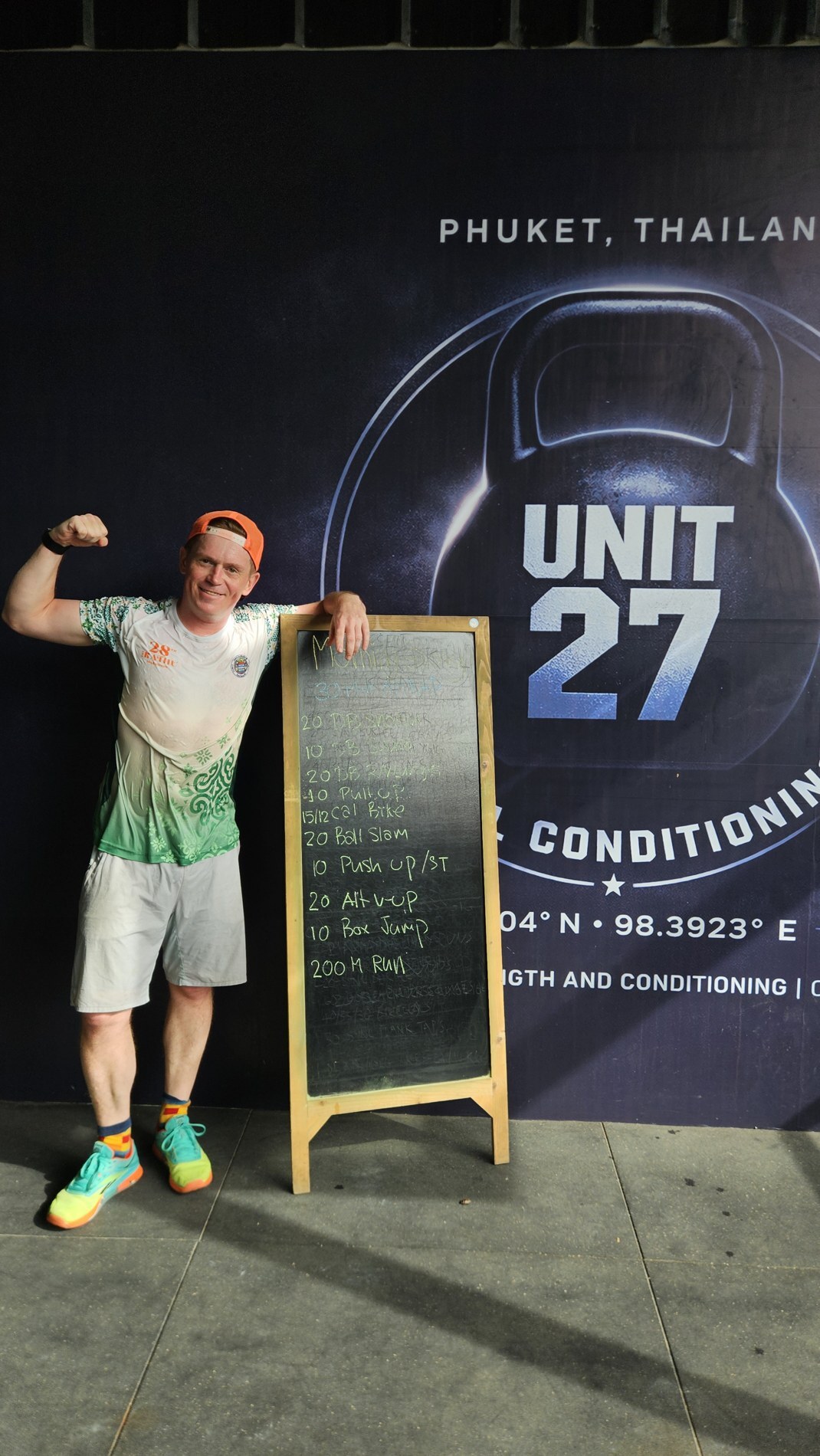 Павел Ростовцев у баннера Unit 27 с доской задания дня