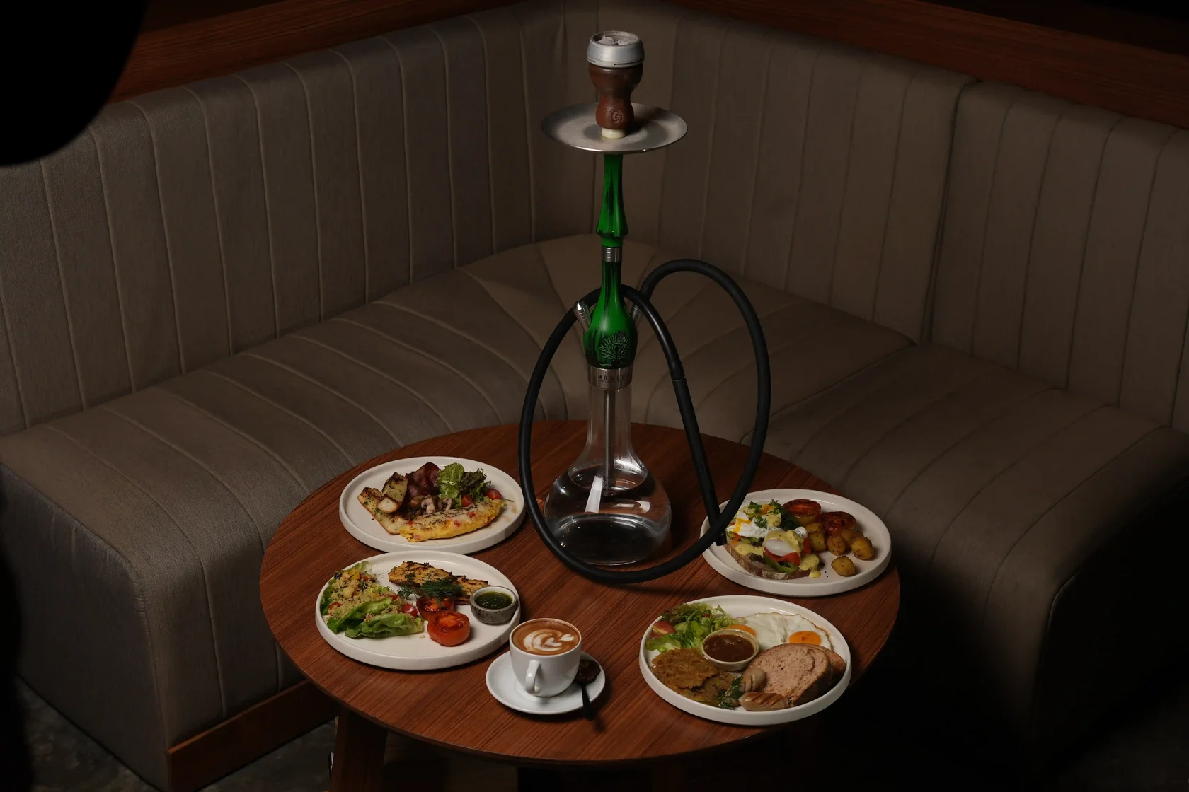 Guest enjoying a relaxing shisha session with food and drinks, a simple way to help prevent and manage a nicotine rush.