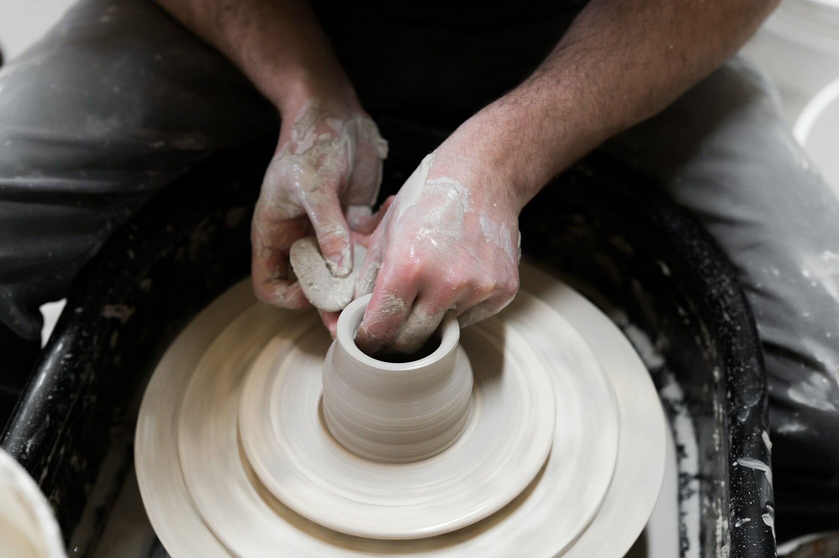 Hands carefully restoring a ceramic piece
