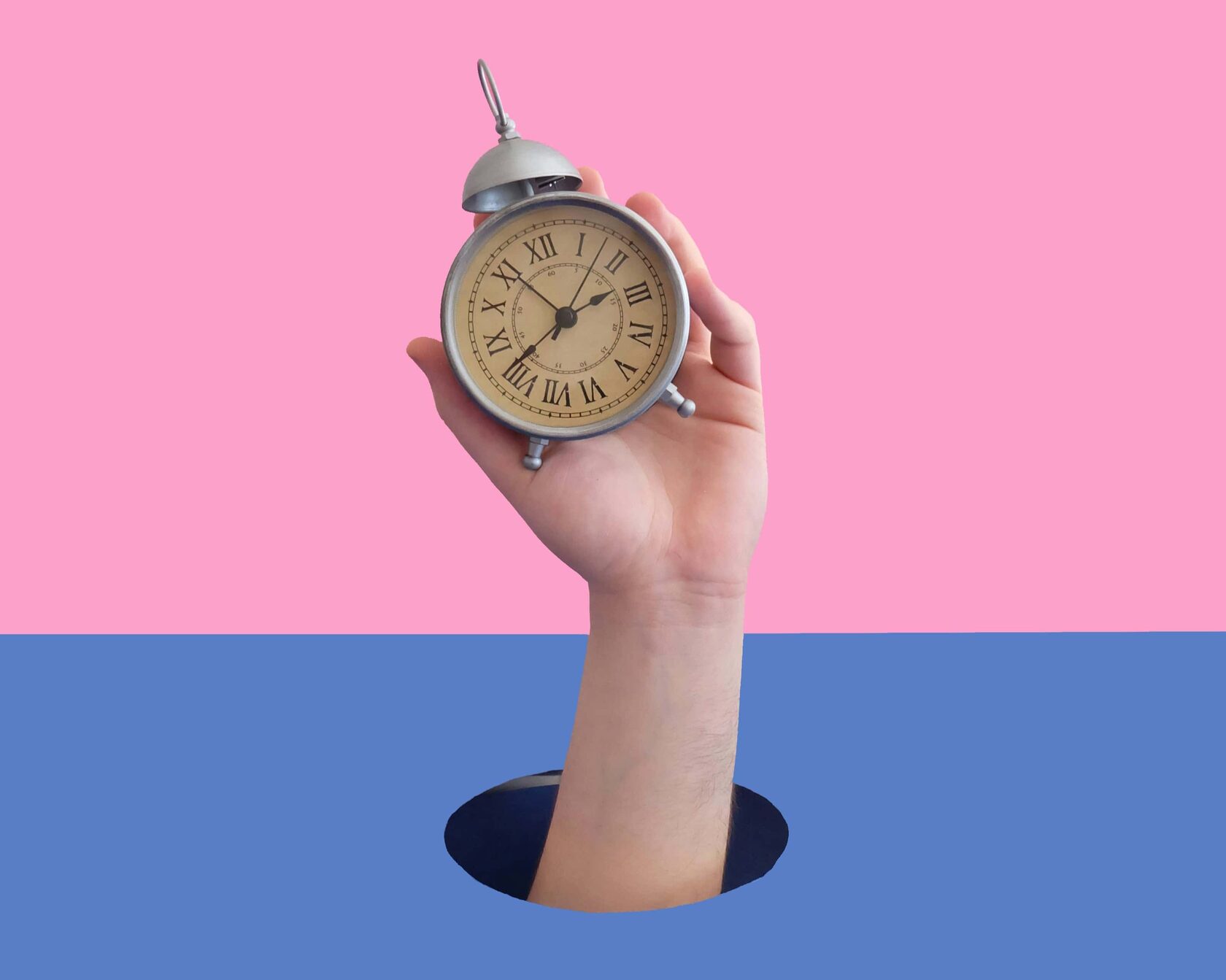 Рука держит часы на цветном фоне