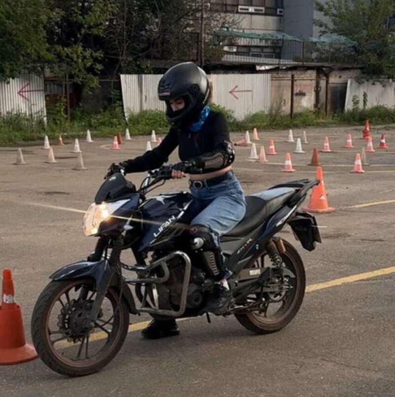 Выпускница автошколы на учебном мотоцикле на автодроме